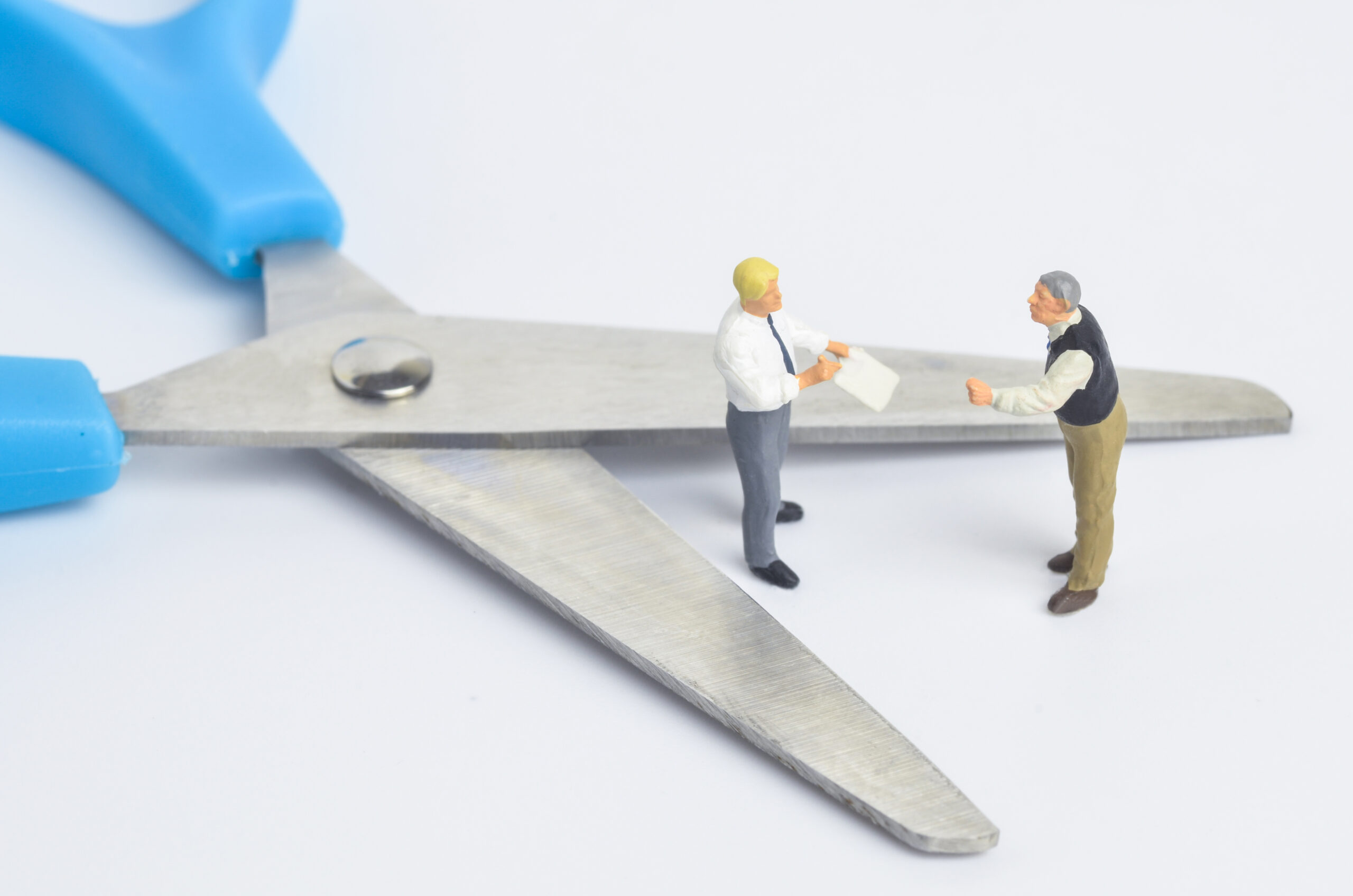 miniature people discussion with scissors on white background